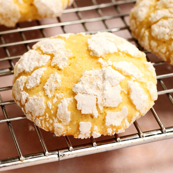 Yellow lemon biscuits with white icing sugar in a crinkle pattern